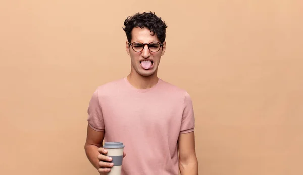 Jovem Homem Bonito Com Café Sentindo Enojado Irritado Furando Língua — Fotografia de Stock