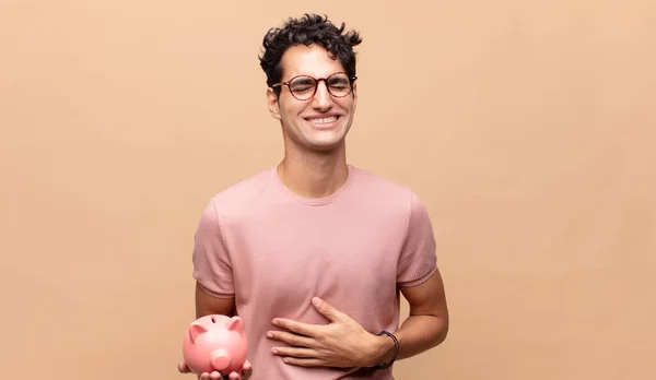 Jovem Com Banco Porquinho Rindo Voz Alta Alguma Piada Hilariante — Fotografia de Stock