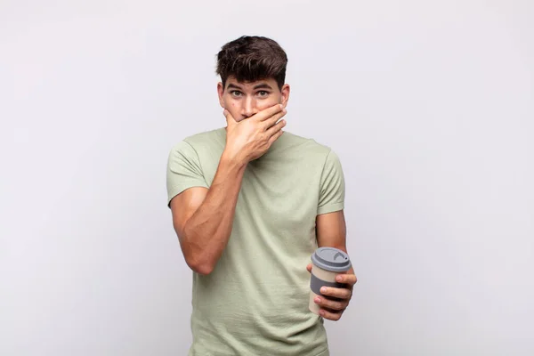 Ung Man Med Kaffe Täcker Munnen Med Händerna Med Chockad — Stockfoto