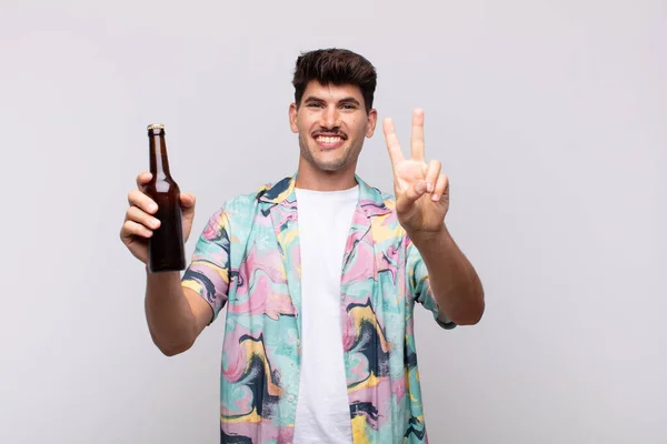 Jeune Homme Avec Une Bière Souriante Amicale Montrant Numéro Deux — Photo