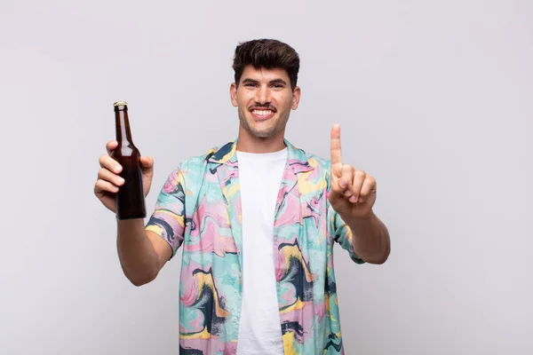 Joven Con Una Cerveza Sonriendo Mirando Amigable Mostrando Número Uno — Foto de Stock