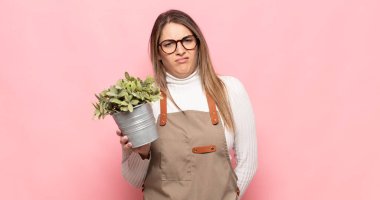 young blonde woman feeling puzzled and confused, with a dumb, stunned expression looking at something unexpected