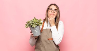 Genç sarışın kadın düşünüyor, kuşkulu ve şaşkın hissediyor, farklı seçeneklerle, hangi kararı vereceğini merak ediyor.