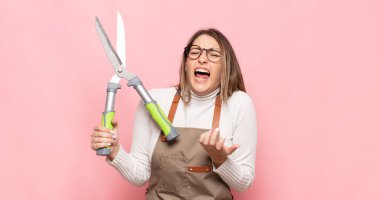 Genç sarışın kadın umutsuz ve sinirli görünüyor, stresli, mutsuz ve sinirli, bağırıyor ve çığlık atıyor.