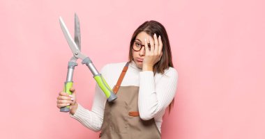 Genç sarışın kadın, yorgun, sıkıcı ve sıkıcı bir işin ardından sıkılmış, hayal kırıklığına uğramış ve uykulu hissediyor.