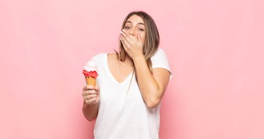 Şok olmuş, şaşırmış bir ifadeyle ağzı kapalı genç sarışın bir kadın sır saklıyor ya da 