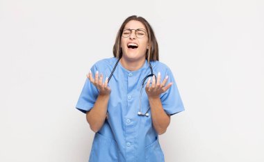 Genç sarışın kadın umutsuz ve sinirli görünüyor, stresli, mutsuz ve sinirli, bağırıyor ve çığlık atıyor.