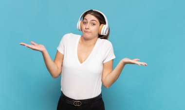 Genç sarışın kadın şaşkın ve şaşkın hissediyor, şüpheci, farklı seçenekleri tartıyor veya komik bir ifadeyle seçiyor.