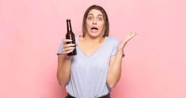 Genç sarışın kadın ellerini havaya kaldırıp bağırıyor. Öfkeli, sinirli, stresli ve üzgün.