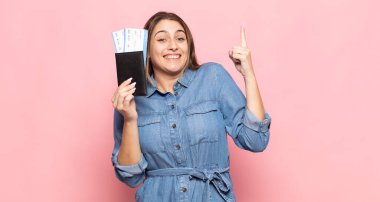 Genç sarışın kadın bir fikri fark ettikten sonra mutlu ve heyecanlı bir dahi gibi hissediyor. Neşeli bir şekilde parmağını kaldırıyor.!