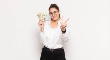 Genç sarışın kadın gülümsüyor ve arkadaş canlısı görünüyor. İki ya da iki numarayı gösteriyor. Elleri önde, geri sayıyor.