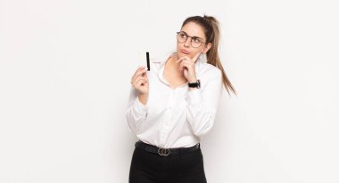 Genç sarışın kadın düşünüyor, kuşkulu ve şaşkın hissediyor, farklı seçeneklerle, hangi kararı vereceğini merak ediyor.