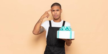 Genç siyah adam şaşkın ve şaşkın hissediyor. Deli, deli ya da aklını kaçırmış olduğunu gösteriyor.