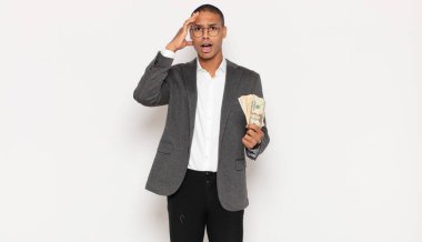 Genç siyah adam mutlu, şaşkın ve şaşırmış görünüyor, gülümsüyor ve inanılmaz ve inanılmaz iyi haberleri fark ediyor.