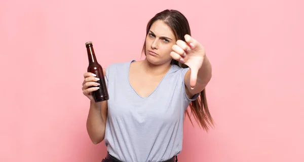 若いブロンドの女性は怒り 失望または不満を感じ 深刻な表情で親指を見せます — ストック写真
