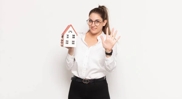 Junge Blonde Frau Lächelt Und Sieht Freundlich Aus Zeigt Nummer — Stockfoto