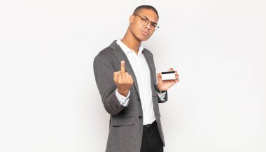 Genç siyahi adam kızgın, sinirli, asi ve agresif hissediyor, orta parmağını sallıyor, karşı koyuyor.