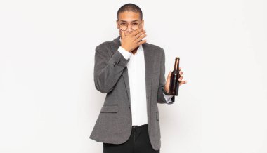 Genç siyahi adam elleri ile ağzını kapatıyor, şok olmuş, şaşırmış bir ifadeyle, sır saklıyor ya da 