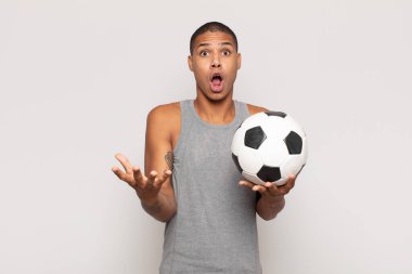 Genç siyahi adam ağzı açık ve şaşırmış, şok olmuş ve hayrete düşmüş inanılmaz bir sürprizle