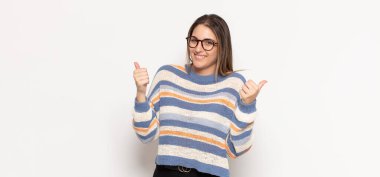 Genç sarışın kadın neşeyle gülümsüyor ve mutlu görünüyor, kaygısız ve pozitif hissediyor.