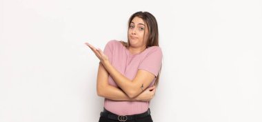 Genç sarışın kadın, kafası karışık ve habersiz, şüpheli bir açıklamayı merak ediyor.