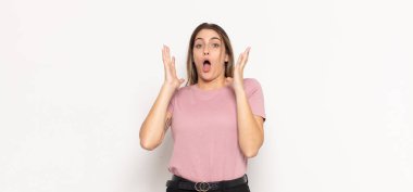 Genç sarışın kadın ellerini havaya kaldırıp bağırıyor. Öfkeli, sinirli, stresli ve üzgün.