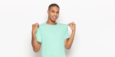 Genç siyah adam kibirli, başarılı, pozitif ve gururlu görünüyor.