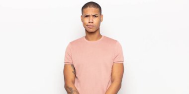 Genç siyahi adam kafası karışık ve şüpheli hissediyor, merak ediyor ya da karar vermeye çalışıyor.