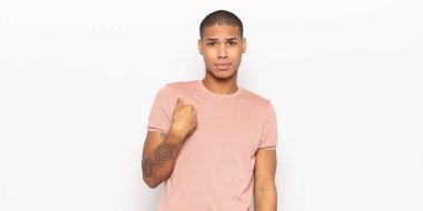 Genç siyahi adam şaşkın, şaşkın ve güvensiz hissediyor, kendini göstererek kim olduğunu soruyor, ben mi??