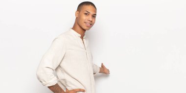 Genç siyah adam kendini mutlu ve neşeli hissediyor, gülümsüyor ve seni selamlıyor, dostça bir jestle içeri davet ediyor.