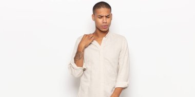 Genç siyahi bir adam stresli, endişeli, yorgun ve hayal kırıklığına uğramış, gömleğini çekiştirmiş, sorunlu görünüyor.