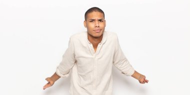 young black man feeling clueless and confused, having no idea, absolutely puzzled with a dumb or foolish look