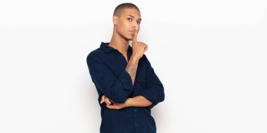 Genç siyahi adam sessizlik ve sessizlik istiyor, parmaklarıyla ağzının önünde işaret ediyor, 