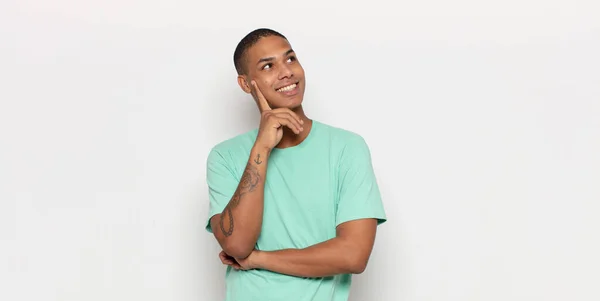 Joven Negro Sonriendo Feliz Soñando Despierto Dudando Mirando Lado — Foto de Stock