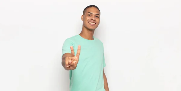 若い黒人男性は笑顔で友好的です前方に手を挙げて2番目または2番目の数字を示し — ストック写真