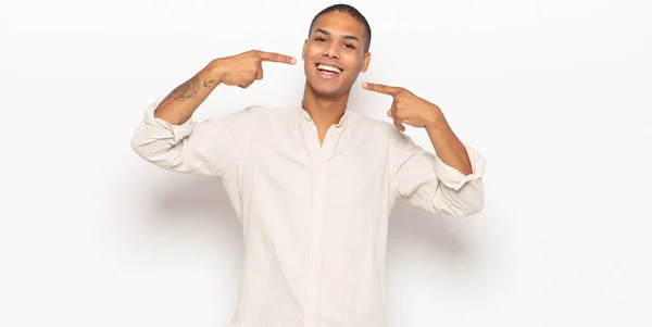 Jovem Negro Sorrindo Confiantemente Apontando Para Próprio Sorriso Largo Positivo — Fotografia de Stock