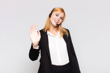 Güzel bir kadın mutlu ve neşeyle gülümsüyor, el sallıyor, seni selamlıyor ve selamlıyor, ya da hoşça kal diyor.