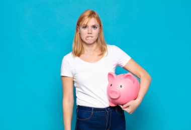 Güzel bir kadın şaşkın ve şaşkın görünüyor. Sinirli bir hareketle dudağını ısırıyor. Sorunun cevabını bilmiyor.