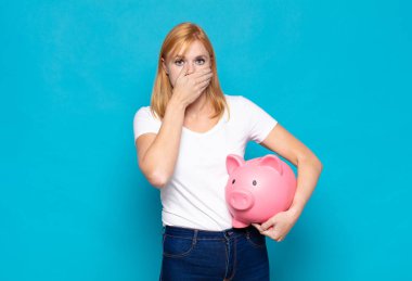 Güzel bir kadın elleri ile ağzını kapatıyor, şok olmuş, şaşırmış bir ifadeyle, sır saklıyor ya da 