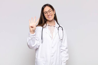 Güzel bir kadın gülümsüyor ve arkadaş canlısı görünüyor, dört ya da dört numarayı gösteriyor, eli önde, geriye doğru sayıyor.