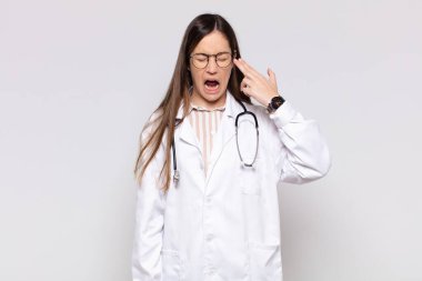 Güzel bir kadın mutsuz ve stresli görünüyor, intihar jesti elle silah işareti yapıyor, kafasını işaret ediyor.