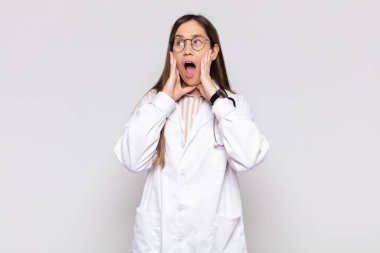 Güzel bir kadın mutlu, heyecanlı ve şaşırmış hissediyor, iki eli yüzü üzerinde yana bakıyor.