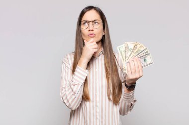 Güzel bir kadın düşünüyor, kuşkulu ve şaşkın hissediyor, farklı seçeneklerle, hangi kararı vereceğini merak ediyor.