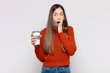 Güzel kadın şok olmuş ve korkmuş hissediyor, ağzı açık ve elleri yanaklarında korkmuş görünüyor.