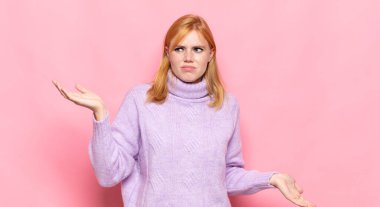 Şaşkın, kafası karışmış ve stresli görünen kızıl saçlı güzel bir kadın. Farklı seçenekler arasında merak ediyor. Belirsiz hissediyor.