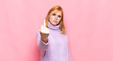 Kızıl saçlı güzel bir kadın kızgın, sinirli, asi ve agresif orta parmağını sallayarak karşılık veriyor.