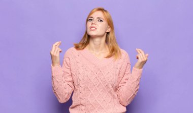 Kızıl saçlı güzel bir kadın endişeyle dua ediyor ve endişeli bir bakışla iyi şanslar diliyor.