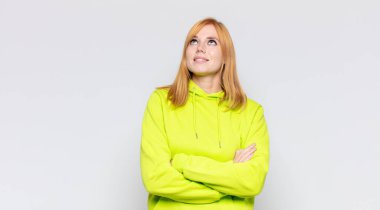 Kızıl saçlı, güzel bir kadın mutlu, gururlu ve umutlu, merak eden ya da düşünen, çapraz kollarla fotokopi çekmek isteyen.