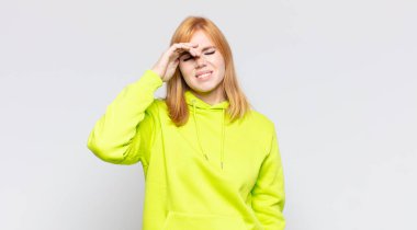 Kızıl saçlı güzel kadın stresli, yorgun ve hayal kırıklığına uğramış, alnından ter damlayan, umutsuz ve bitkin hisseden.