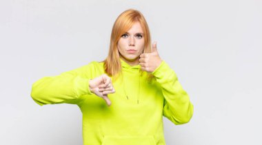 Kızıl saçlı güzel kadın kafası karışık, bilgisiz ve kararsız hissediyor, iyi ve kötü seçenekleri farklı seçeneklerde tartıyor.